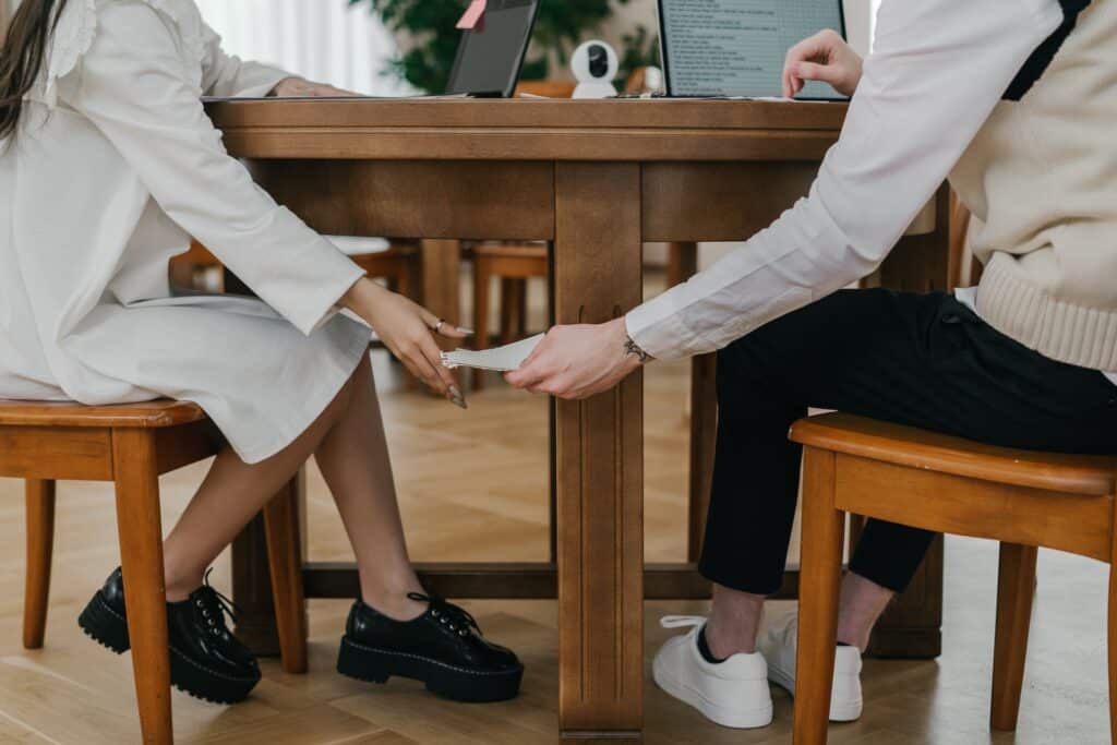 people passing a note under the table